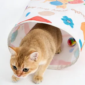 Detailansicht einer goldenen Katze, die aus einem knisternden Katzentunnel mit bunten Motiven kommt