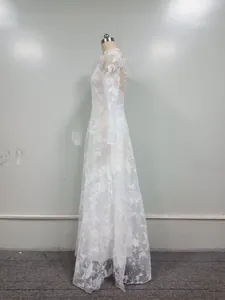 Side view of white heavy lace wedding dress with floral embroidery and long sleeves.