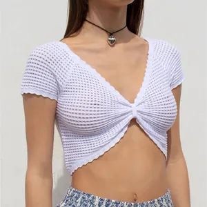 Dettaglio del crop top bianco in maglia traforata con sexy scollo a V
