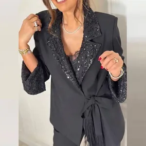 Detailansicht eines schwarzen Damen-Blazers mit Paillettenrevers und Fransen-Bindegürtel
