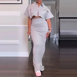 Elegante conjunto de dos piezas gris con top corto y falda larga ajustada de mujer