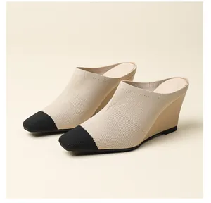 Gros plan de mules à talon compensé en maille avec bout rapporté noir élégant.