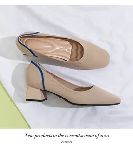 Elegant beige knitted block heel pumps with blue trim details on a white fabric background