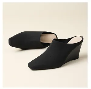 Vue détaillée des élégantes mules compensées en maille noire avec une pointe effilée