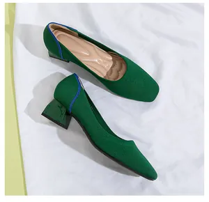Detail view of green knit square-toe pumps with stable block heels
