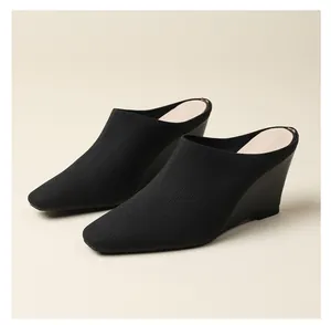 Détail des mules compensées en maille noire pour femmes montrant la texture fine
