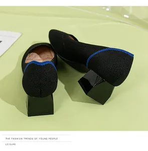 Close-up detail of black knit square toe pumps featuring a chunky block heel design