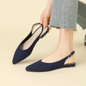 Ballerine slingback in maglia blu scuro a punta da donna, mostrate in posa alla moda