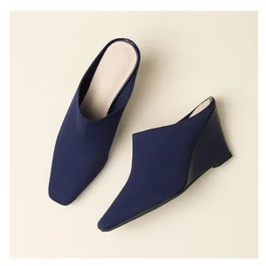 Mules compensées en maille bleu marine avec bout pointu fermé et design à enfiler.