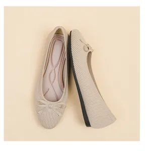 Detailed macro view of beige knit ballet flats featuring a decorative bow on round toe.