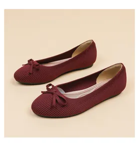 Detail showing burgundy ribbed knit flat ballet pumps with decorative bow on round toe