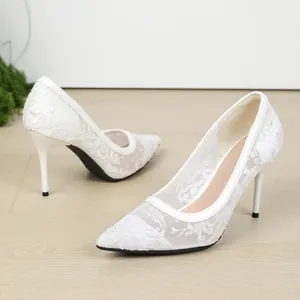 Elegantes tacones blancos de encaje bordado con punta fina y un diseño de aguja fino