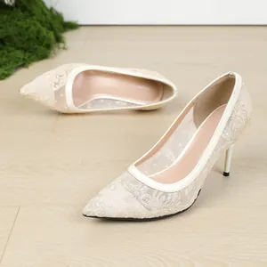 Vista detallada de elegantes zapatos de salón con bordado de encaje y punta fina.