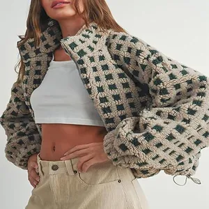 Close-up detail of a stylish women's checkered sherpa fleece jacket with cozy texture