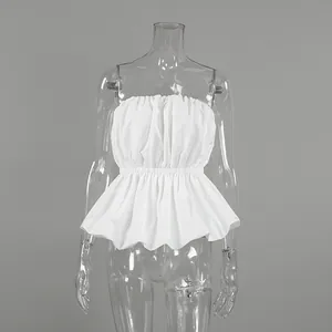 Detail view of a chic white strapless tube top with ruched waist and peplum hem.