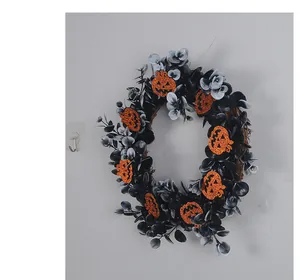 Detailed view of Halloween wreath with black leaves and glittery orange pumpkins