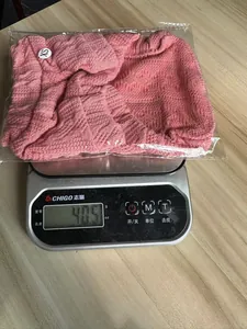 Detailansicht zeigt das Gewicht des rosafarbenen gestrickten Haustierpullovers auf einer Waage