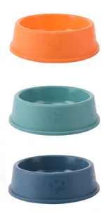 Detail view of three colorful pet bowls with embossed paw prints on a white background.