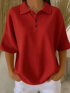 Detailed view of women's red waffle knit short sleeve polo shirt with button collar