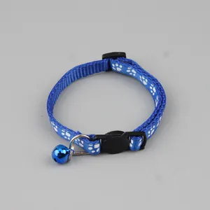 Detailweergave van de blauwe kattenhalsband met witte voetafdrukken en blauwe bel