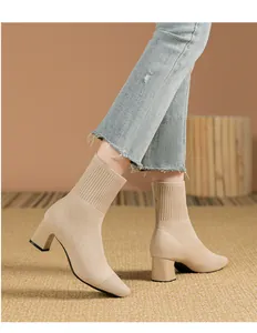 Vista lateral de botines de punto beige con punta cuadrada y tacón ancho usados con jeans