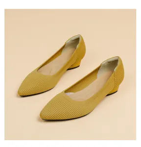 Dettaglio di scarpe gialle in maglia a punta con tacco basso e trama a righe