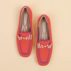 Λεπτομερής κάτοψη πορτοκαλί πλεκτών loafers με διακόσμηση από πέρλες και τετράγωνη μύτη