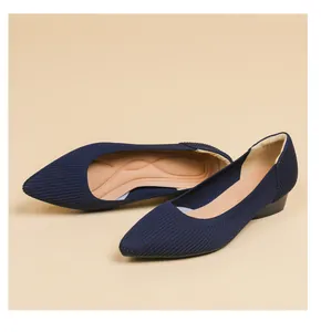 Primo piano di scarpe basse in maglia blu scuro a punta traspiranti con supporto per l'arco