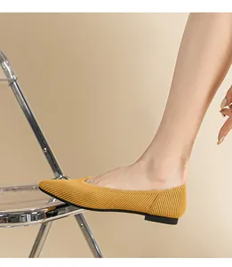 Detail van gele geribbelde gebreide spitse ballerina's aan de voet voor de zomer.