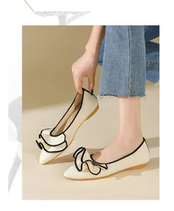 Detailansicht eleganter gewebter Ballerinas mit schwarzen Rüschen-Schleifen-Details