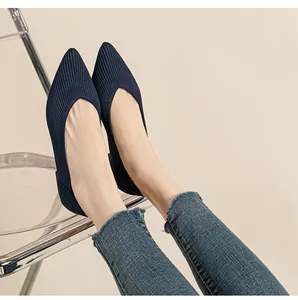 Elegante marineblauwe gebreide ballerina's met puntige neus gedragen met casual jeans