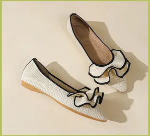 Detailansicht cremefarbener Strick-Ballerinas mit einer schicken schwarz gerandeten Rüsche.