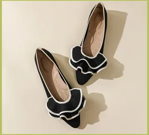 Detailansicht schwarzer Netz-Ballerinas mit weiß umrandeten Rüschen und Latexsohle.