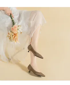Vista dettagliata di eleganti décolleté kaki in maglia traspirante con gonna bianca