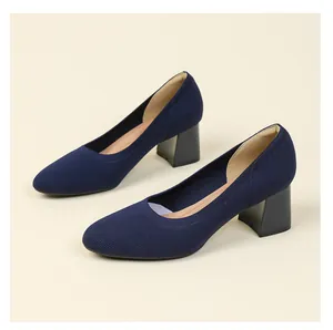 Detailweergave van de marineblauwe gebreide pumps met blokhak en een ademende textielafwerking.