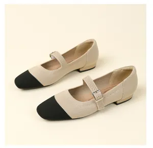 Detailed view of beige and black knit Mary Jane shoes with adjustable buckle strap.