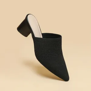 Primo piano di un elegante sabot in maglia nera a punta con dettaglio tacco largo di 5 cm