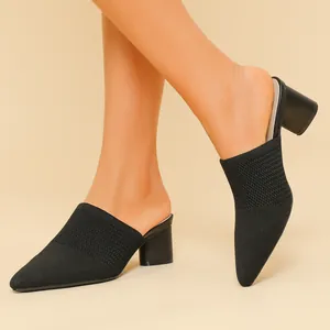 Dettaglio di eleganti sabot in maglia nera con un tacco a blocco stabile da 5 cm