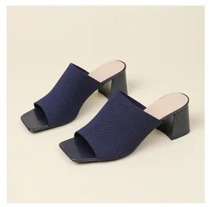 Primer plano de sandalias de punto azul marino con tacón de bloque y punta cuadrada.