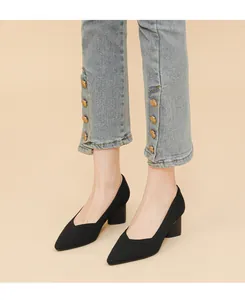 Chic black pointed-toe block heel pumps featuring ribbed texture shown on a model feet