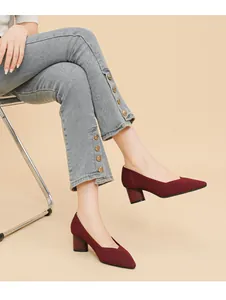 Elegant burgundy ribbed block heel pumps with pointed toe shown on a seated model