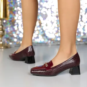 Dettaglio delle décolleté bordeaux da donna con trama coccodrillo e tacco largo.