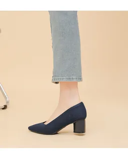 Detail view of navy blue ribbed pointed-toe block heel pump with V-shaped neckline.