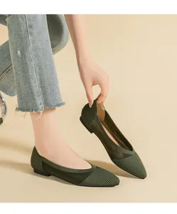 Detail showing the dark green woven pointed flats with breathable knit mesh texture