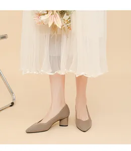 Detailed view of tan pointed-toe pumps with vertical rib texture and thick heels.