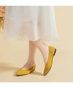 Detailed view of yellow knitted pointed-toe flat shoes with comfortable breathable texture