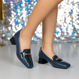 Vista dettagliata delle décolleté in pelle verniciata blu navy effetto coccodrillo.