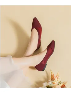 Detailed view of burgundy knitted pointed-toe flats with elegant lace hollow design