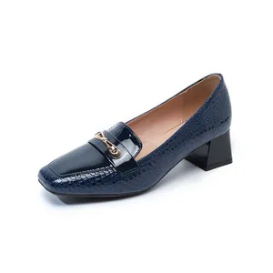 Vista dettagliata dei mocassini in vernice blu navy con punta quadrata e fibbia dorata