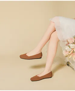 Detailed close-up of brown breathable knit square toe ballet flats worn with elegant skirt